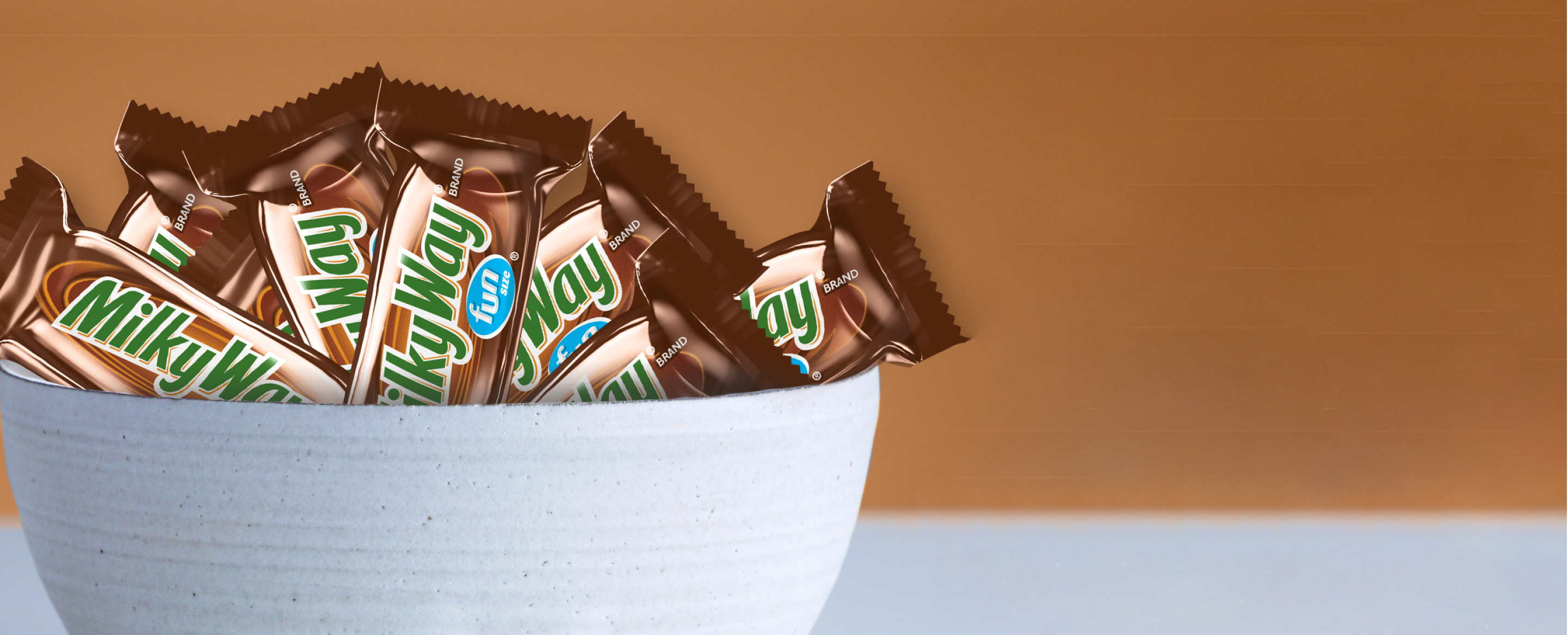 Seven Milkyway fun size bars together in a white bowl