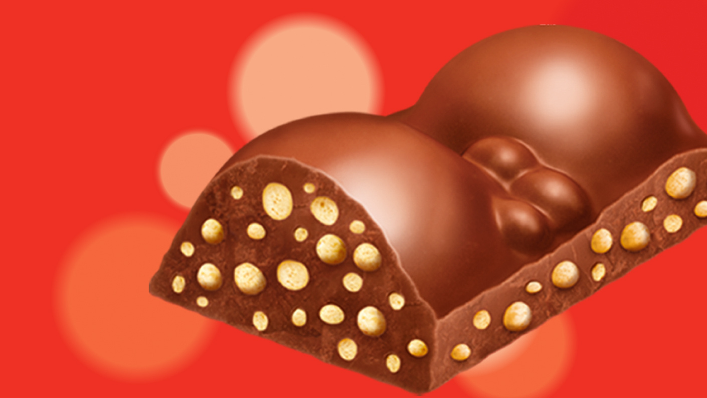 Een stukje van een Maltesers Teaser op een rood gevlekte achtergrond