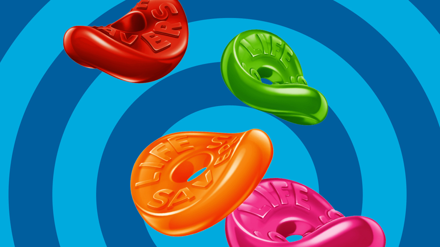 Various unpackaged Life Savers on top of blue circular background