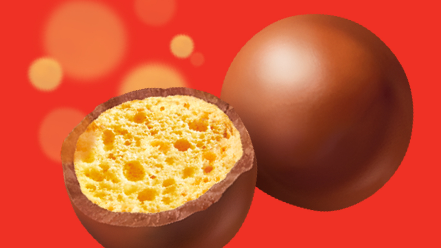 A half and whole Malteser on a red background