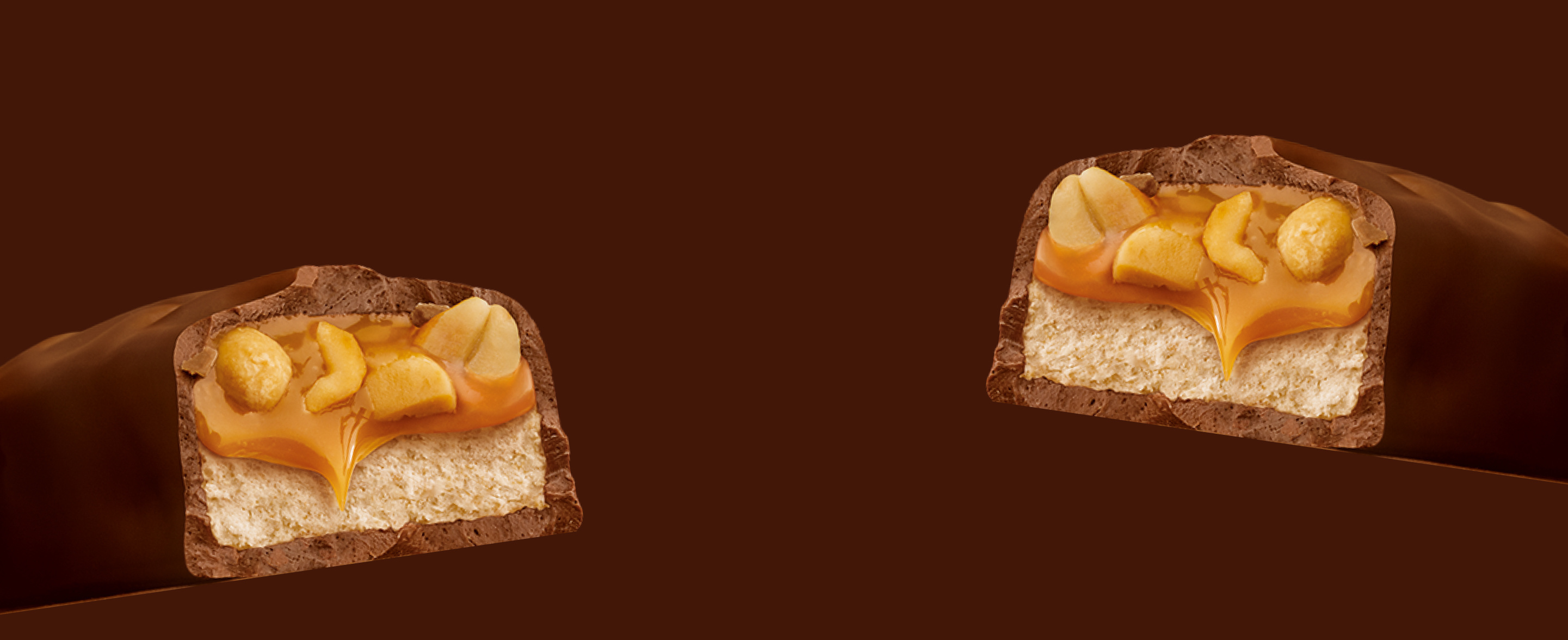 Zwei Querschnitte eines klassischen Snickers-Schokoriegels auf braunem Hintergrund
