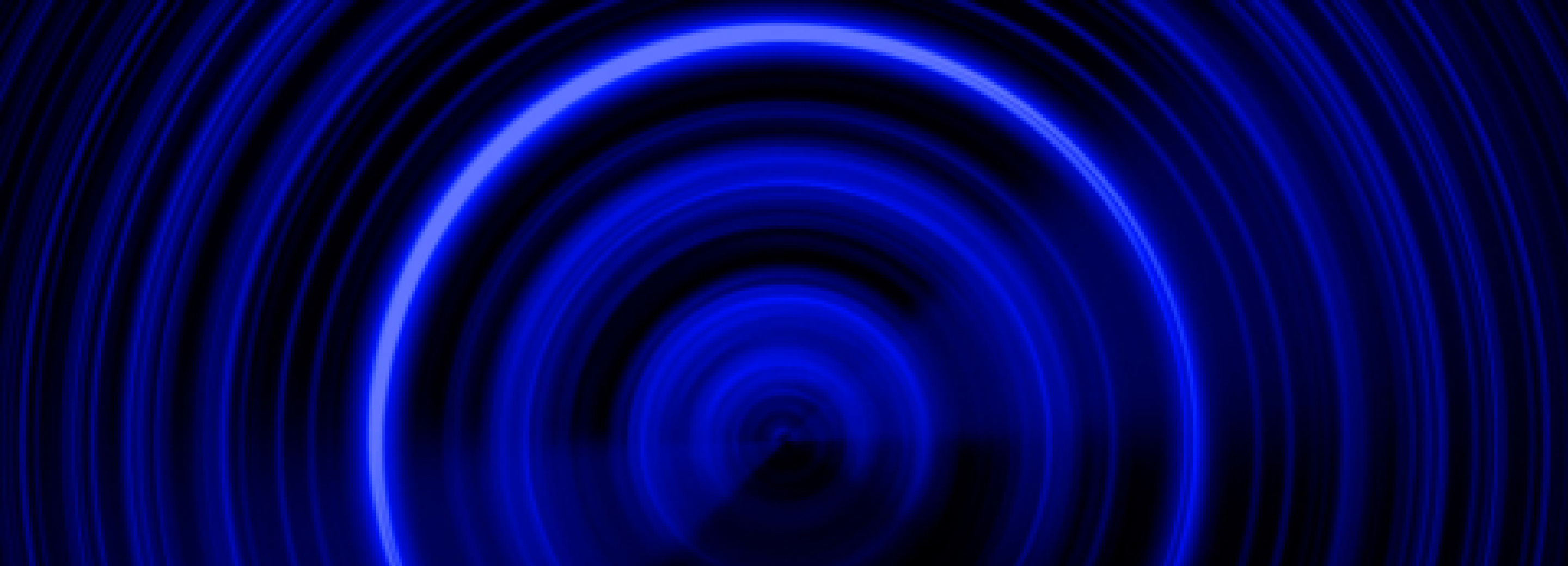 Abstract and circular neon blue light pattern over a dark background