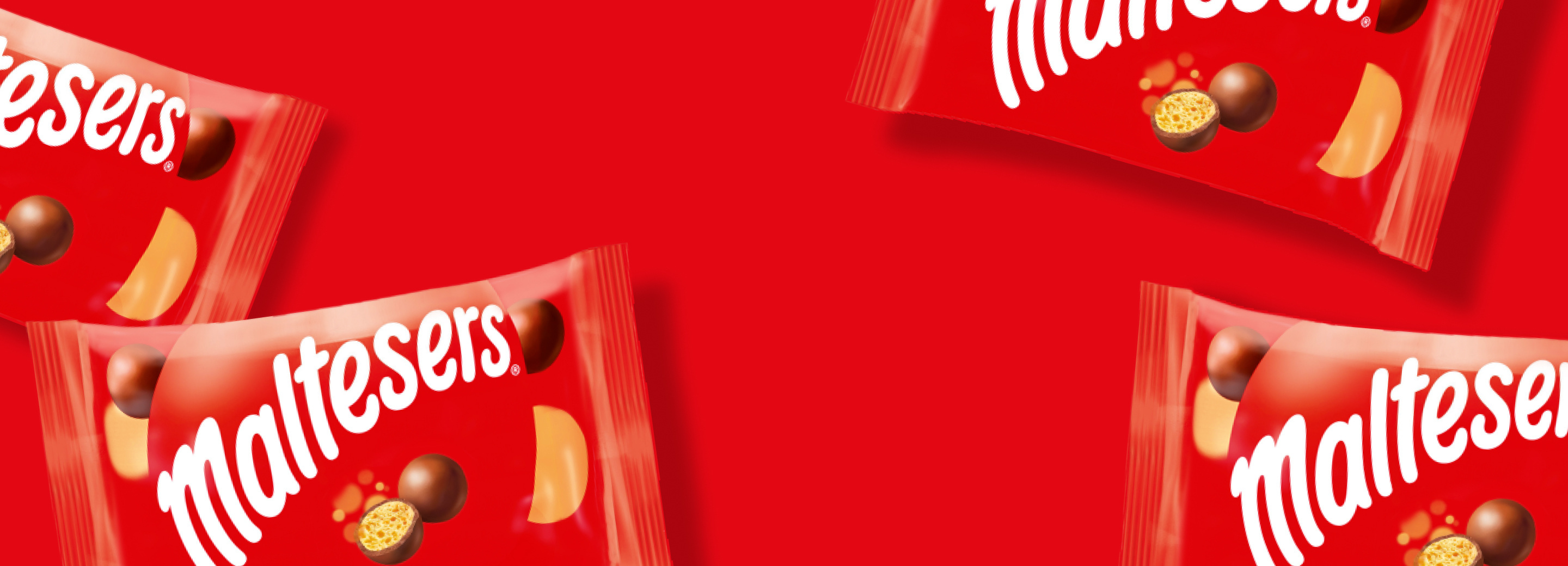 Bags of Maltesers on a red background