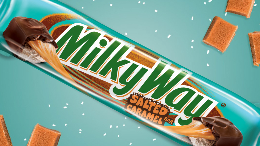 Packaged Salted Caramel Milkyway bar on aqua colored background with salt and caramel pieces