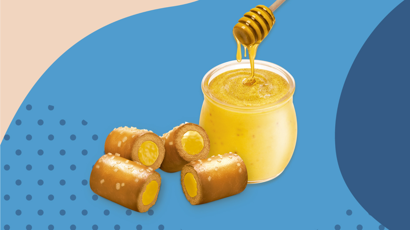 Bowl of honey next to Spicy Honey Mustard Combos on a blue patterned background