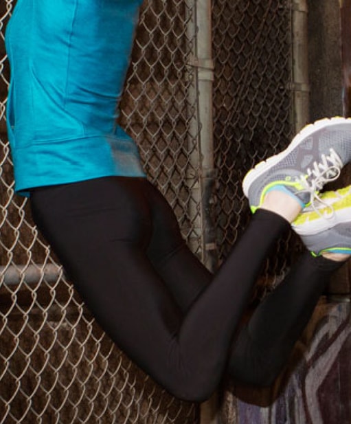 Person jumping up in a dramatic fashion in front of an urban background