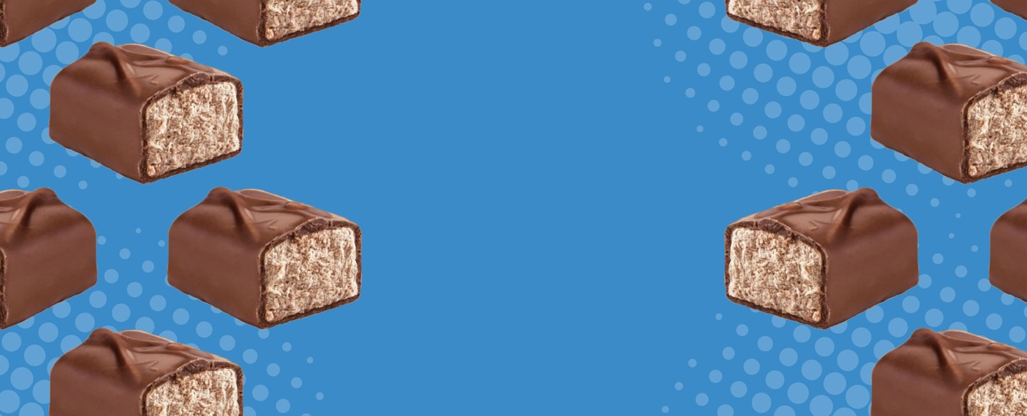 Cross-section view of 3 musketeers mini bars across blue patterned background